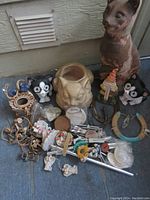 Overview of various yard art items including cat figurines, cat planter, wind chimes, horseshoes, and small decorative pieces