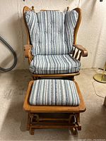 Full view of the rocking chair and ottoman together showing wood frame and striped cushions.