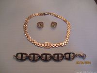 Photo showing Italy bronze bracelet, Stella Valle gold tone logo necklace, and two earrings