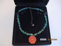 Necklace displayed in original box on black cushion, showing overall design and box