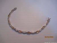Full view of yellow citrine and sterling silver tennis bracelet laid flat to show entire length and clasp.