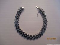 Top-down view of full bracelet showing arrangement of round green stones in silver settings.