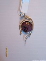 Front view showing the deep red Eudialyte stone with black inclusions set in sterling silver.