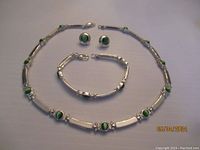 Full set including necklace, bracelet and earrings laid out on a flat surface
