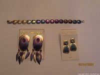 Photo showing both sets of earrings and the bracelet laid flat on a surface for an overview