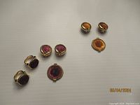 Full view of the jewelry lot: two pairs of clip-on earrings and two rings with intaglio cameo profiles in glass.