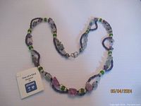 Full view of Jeanne artisan necklace with alternating frosted glass and fluorite beads on purple cord.
