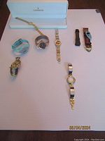 Overall arrangement of six watches and two spare watch bands on white background