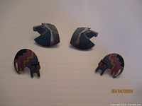 Two pairs of Laura Burch vintage clip-on earrings on a flat beige background; one pair shows horse heads and the other colorful stylized cats