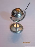 Front side view of the sterling silver globe with stand and attached chimney
