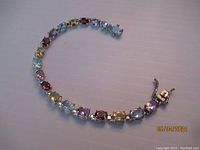 Full view of the multi gemstone sterling silver bracelet showing the variety of colored stones and box clasp.