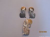 Photo of three pieces in the lot: a brooch and matching pair of earrings depicting stylized howling wolves with golden suns behind, crafted in sterling silver with etched details.