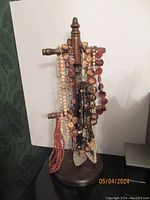 Jewelry necklace stand holding multiple assorted fashion necklaces, showing an overview of the lot.