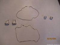 Lot of sterling silver jewelry laid flat on neutral surface - shows two pairs of earrings and two necklaces.