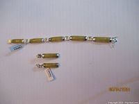 Yellow jade and sterling silver bracelet laid out flat with clasp and multiple linked rectangular stones