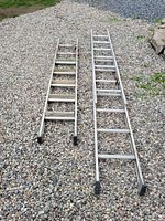 Two aluminum ladders placed side by side on gravel surface, showing overall length and rubber feet caps.