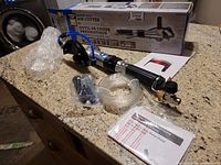 Full view of the Power Fist water feed air cutter in box along with cutting tool, blue water feed hose, and user manuals.