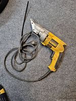 Side view of DeWalt metal shear showing yellow housing, integrated cord and metal cutting head