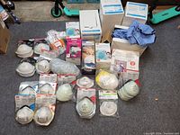 Overview of all masks, boot covers, gloves, and respirators laid out showing brand labels.