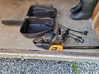 Poulan Pro 18 inch chainsaw with plastic case open and two extra chains on ground.