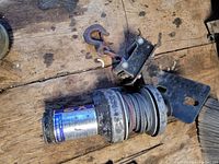 Top view of the Superwinch X2 electric winch showing the motor housing, cable drum wound with steel wire cable, and attaching hook with mounting bracket.