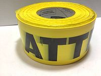 Close-up photo showing yellow vinyl tape with large black letters 'ATT' from "ATTENTION"