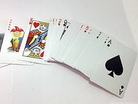 Top view of playing cards showing jokers and multiple face cards such as King of Hearts, cards in a spread.