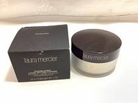 Full view of the black box and frosted glass jar of Laura Mercier Translucent Loose Setting Powder with dark brown lid.
