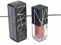 Photo of NARS Velvet Lip Glide Bound lip gloss in original packaging, showing front and side of box and gloss tube with black cap and white NARS logo.