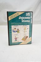 Front view of cassette case cover with title '101 Japanese Idioms' showing illustrations and text about the language program