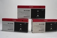 Three Canon PFI-701BK compatible black ink cartridge boxes shown, two stacked horizontally and one upright, packaging white with red and black design.