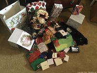 Overview shot showing multiple gift bags, boxes, and a soft Santa figure decoration.