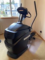 Photo of entire Octane elliptical fitness machine showing its overall shape and structure in a room near window.