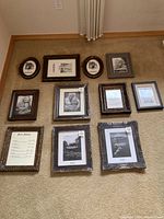 Multiple picture frames on carpet arranged in rows, various shapes and sizes, most dark wood finish, new condition