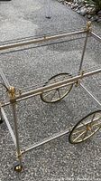 Close-up photo of the metal frame and large spoked wheels of the mid-century modern bar cart.