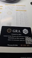Photo of warranty card from GRA showing authenticity and certification details.