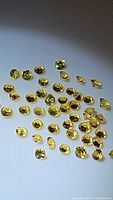 Close-up photo showing multiple small round cut yellow sapphires with bright yellow color and high clarity.