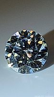 Close up top view of the round brilliant cut moissanite showing facets and fire.