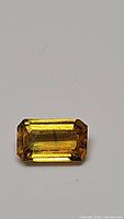 Close-up of deep golden yellow emerald cut sapphire showing color and facets