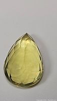 Front view of pear-shaped natural lemon citrine gemstone showing smooth faceting and bright yellow color.