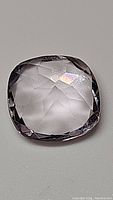 Close-up photo of 2.60ct cushion cut natural pink amethyst gemstone showing transparency, clarity and faceted surface.