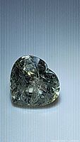 Close-up image of the heart-shaped pastel light green sapphire showing cut and clarity.