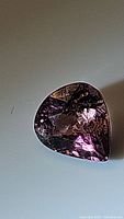 Front view of pear cut pink tourmaline gemstone showing facets and internal reflections.