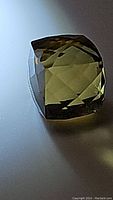 Photo showing the light Madeira citrine gemstone with a fancy cube cut and clear faceting