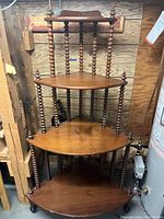Full view of the antique wooden corner shelf unit showing four corner shelves and turned spindle supports.