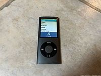 Front view of black Apple iPod nano showing menu screen interface with options including Videos and Photos.