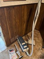 Full view of Electrolux canister vacuum with hose, power brush, attachments, and vacuum bags on floor.