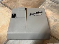 Top view of the Electrolux Sidekick vacuum attachment showing the brand name and on/off switch.