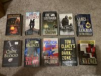 Top view of 10 fiction books arranged in two rows showing front covers including titles and authors.