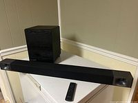 Complete Klipsch Reference Bar 40 soundbar system with subwoofer and remote control displayed on a white surface.
